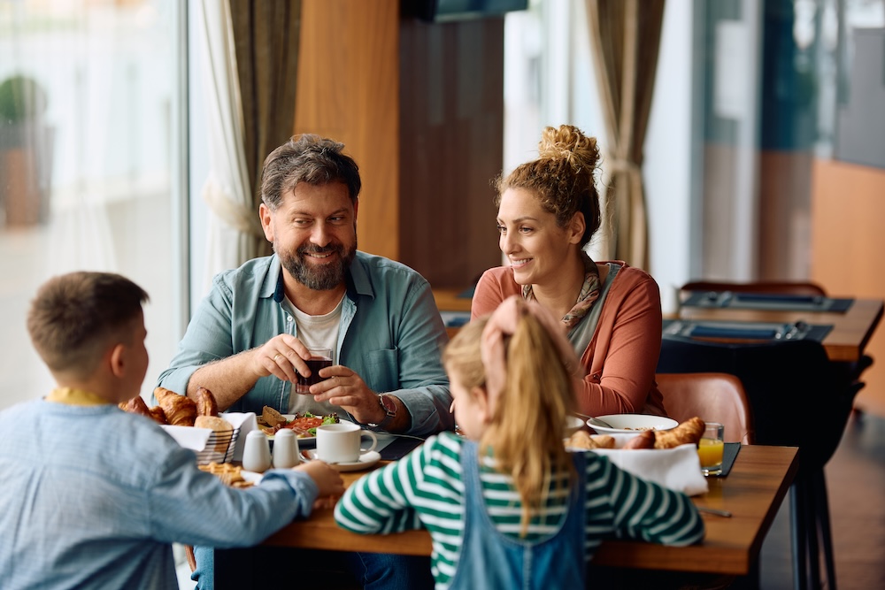 family eating breakfast together at restaurant 